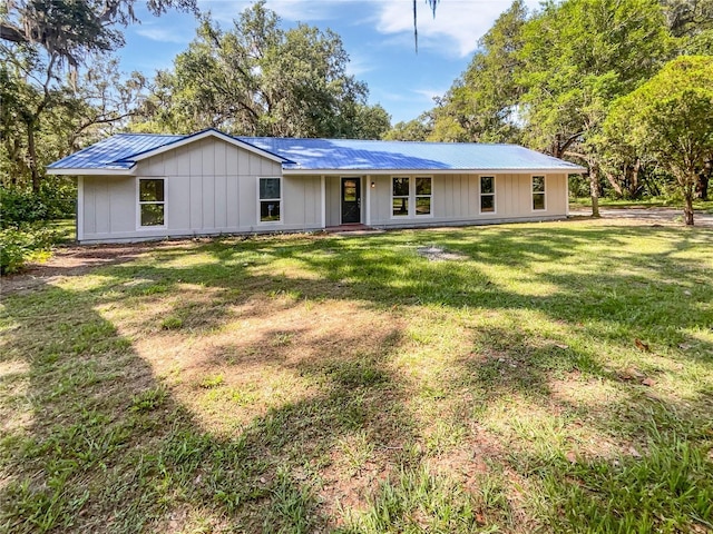 13794 SW 112th St, Dunnellon, FL 34432 - view of front of home featuring a front lawn, metal roof, and board and batten siding