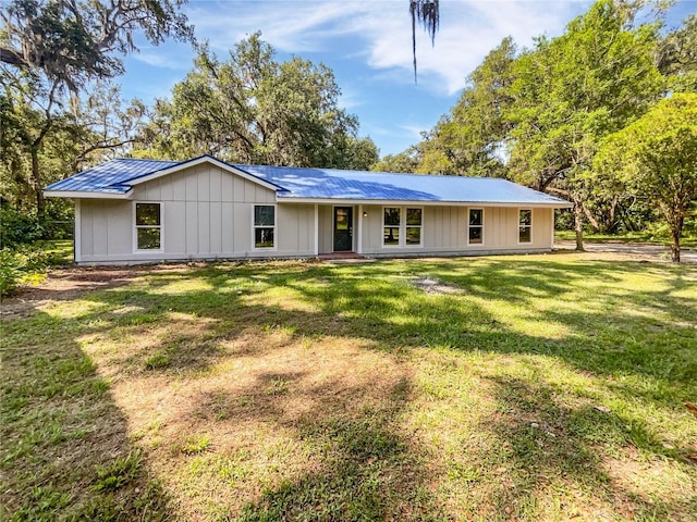 13794 SW 112th St, Dunnellon, FL 34432 - view of front facade featuring metal roof, a front yard, and board and batten siding