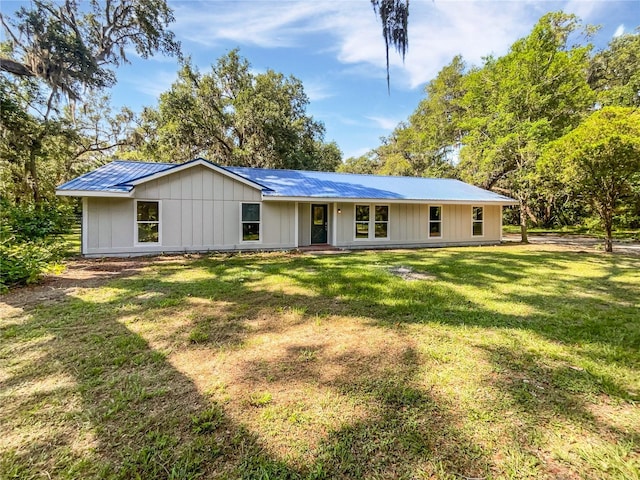 13794 SW 112th St, Dunnellon, FL 34432 - view of front of house featuring metal roof, board and batten siding, and a front yard