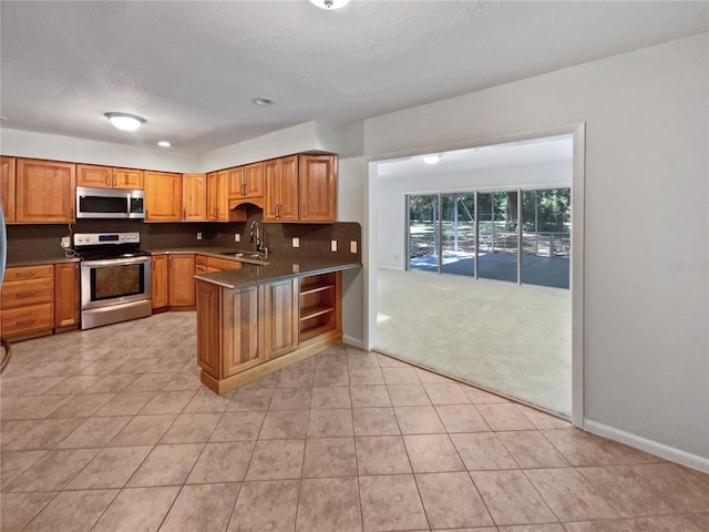 13794 SW 112th St, Dunnellon, FL 34432 - kitchen featuring stainless steel appliances, a sink, a peninsula, baseboards, and backsplash