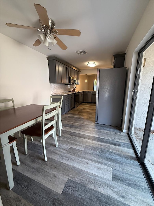 kitchen with appliances with stainless steel finishes, healthy amount of natural light, ceiling fan, and light countertops