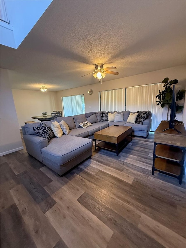 living area with wood finished floors, a textured ceiling, and a ceiling fan