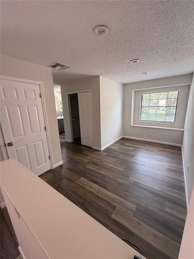 spare room with dark wood-style flooring and a textured ceiling