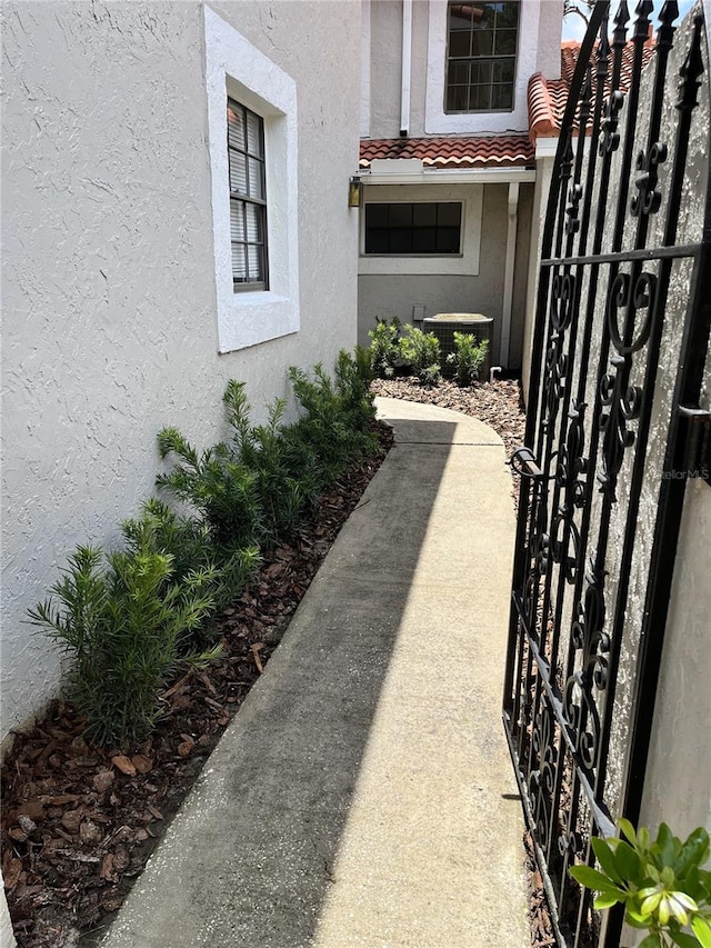 property entrance featuring stucco siding, a tiled roof, and a gate