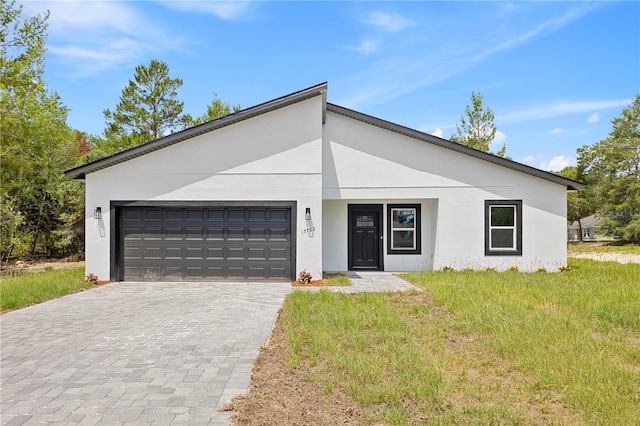 17762 SW 33rd Ter, Ocala, FL 34473 - view of front of house with a garage, decorative driveway, stucco siding, and a front lawn