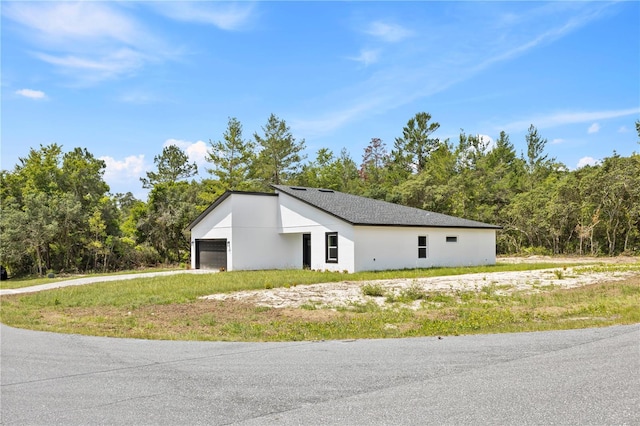 17762 SW 33rd Ter, Ocala, FL 34473 - view of home's exterior with an attached garage, stucco siding, and a forest view
