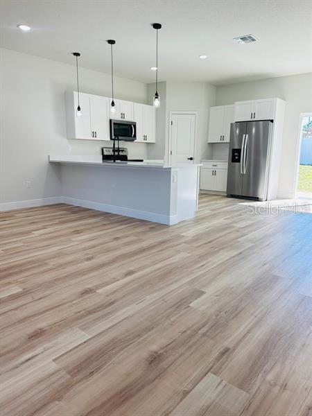17762 SW 33rd Ter, Ocala, FL 34473 - kitchen with appliances with stainless steel finishes, white cabinets, light wood-style floors, and recessed lighting