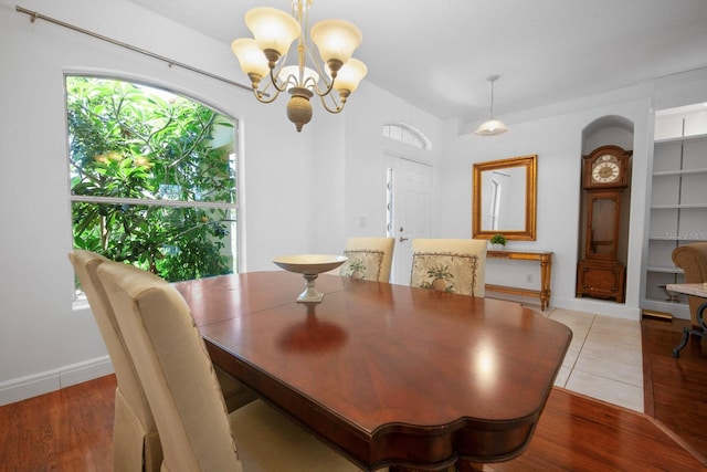 13631 Via Roma Cir, Clermont, FL 34711 - dining area featuring a chandelier, built in shelves, and light wood-style floors