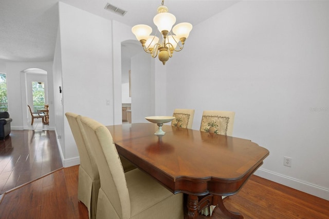 13631 Via Roma Cir, Clermont, FL 34711 - dining space featuring arched walkways, a chandelier, and wood finished floors
