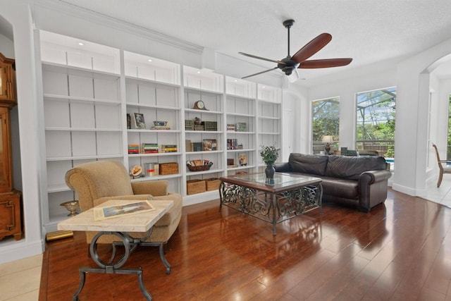 13631 Via Roma Cir, Clermont, FL 34711 - living room with arched walkways, ceiling fan, wood finished floors, built in shelves, and a textured ceiling