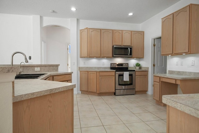 13631 Via Roma Cir, Clermont, FL 34711 - kitchen featuring stainless steel appliances, arched walkways, light brown cabinets, light countertops, and recessed lighting