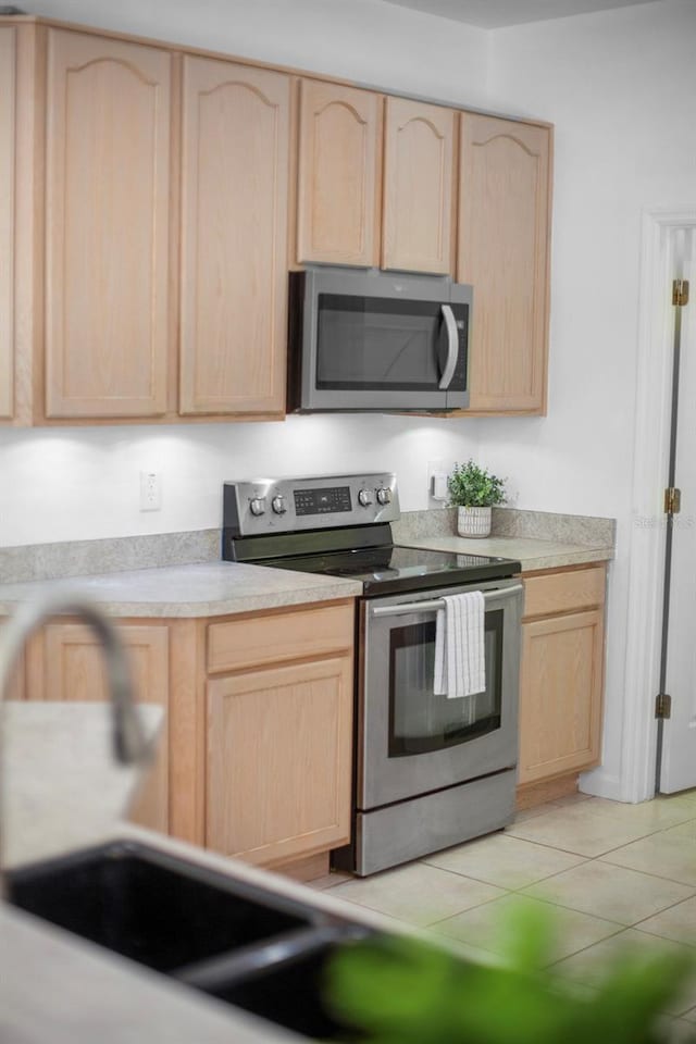 13631 Via Roma Cir, Clermont, FL 34711 - kitchen with light brown cabinetry, appliances with stainless steel finishes, and light countertops