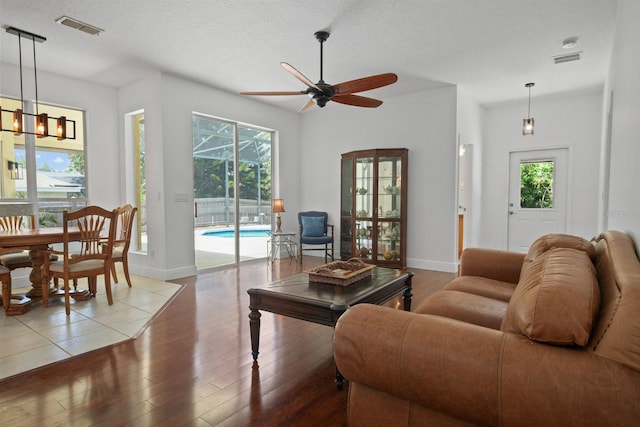 13631 Via Roma Cir, Clermont, FL 34711 - living area with wood-type flooring, ceiling fan, healthy amount of natural light, a chandelier, and a textured ceiling