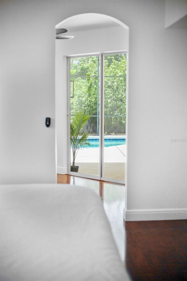 13631 Via Roma Cir, Clermont, FL 34711 - unfurnished bedroom with access to exterior, arched walkways, and wood finished floors