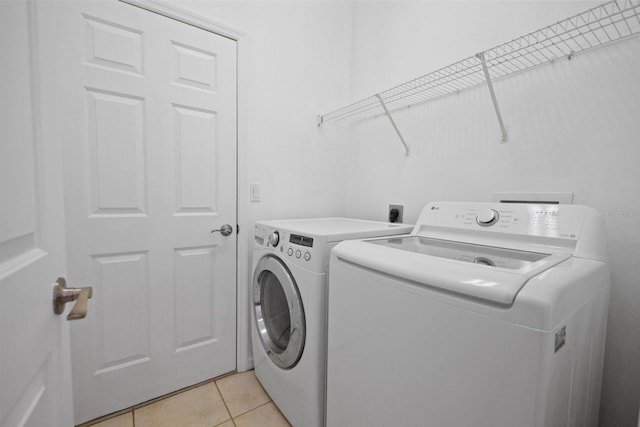 13631 Via Roma Cir, Clermont, FL 34711 - laundry area with washer and clothes dryer and light tile patterned flooring