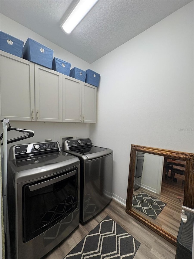 1212 Georgia Trace Ave, Valrico, FL 33596 - laundry room with cabinet space, separate washer and dryer, wood finished floors, a textured ceiling, and baseboards
