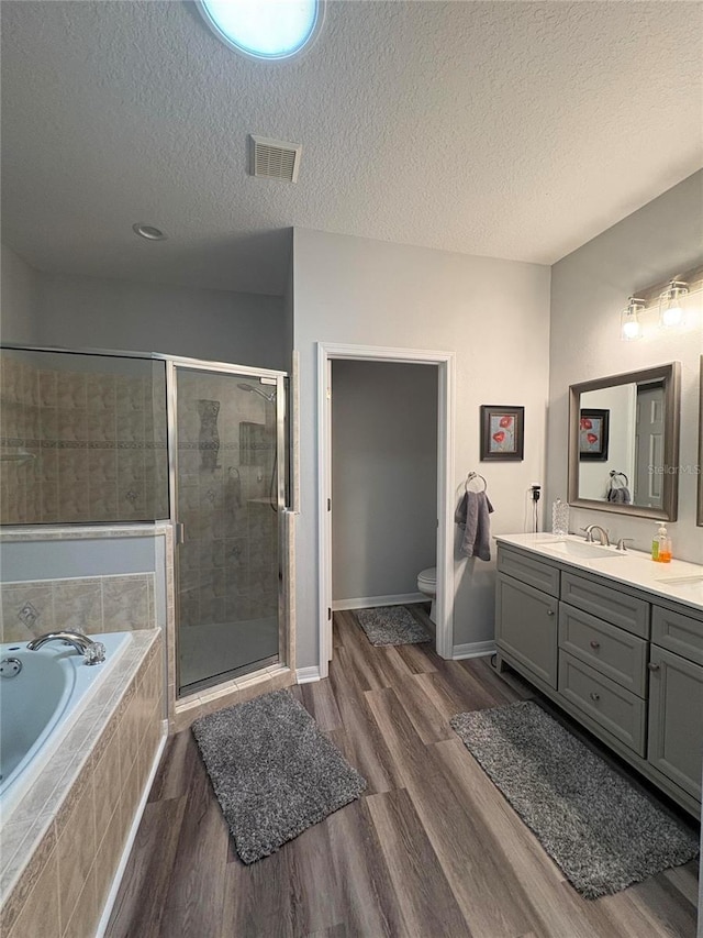 1212 Georgia Trace Ave, Valrico, FL 33596 - full bathroom featuring vanity, a garden tub, a stall shower, toilet, and wood finished floors