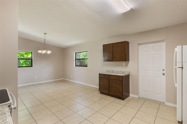 212 Homewood Dr, Sanford, FL 32773 - kitchen with freestanding refrigerator, dark brown cabinets, a chandelier, hanging light fixtures, and light tile patterned floors