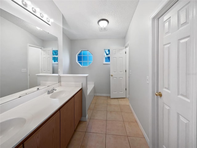 612 Doe Cove Pl, Apopka, FL 32703 - bathroom featuring double vanity, a textured ceiling, a garden tub, tile patterned floors, and baseboards