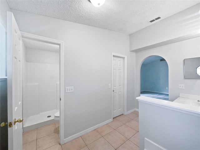 612 Doe Cove Pl, Apopka, FL 32703 - hall with a textured ceiling, light tile patterned floors, and arched walkways