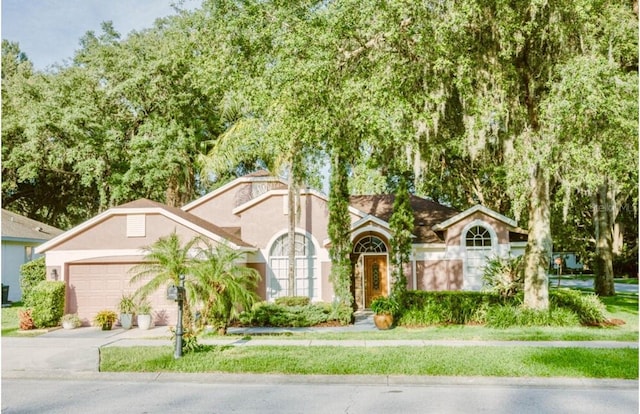 2102 Applegate Dr, Ocoee, FL 34761 - view of front of property with stucco siding, a garage, and driveway