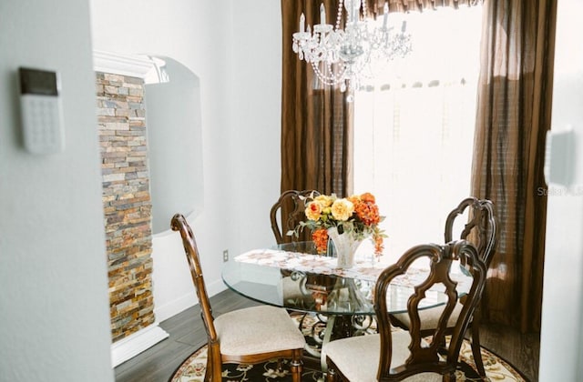 2102 Applegate Dr, Ocoee, FL 34761 - dining area featuring arched walkways, wood finished floors, and a chandelier
