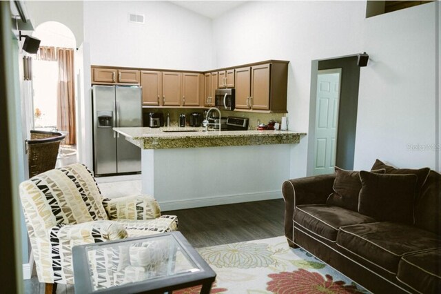 2102 Applegate Dr, Ocoee, FL 34761 - kitchen with appliances with stainless steel finishes, high vaulted ceiling, light wood-type flooring, decorative backsplash, and a peninsula