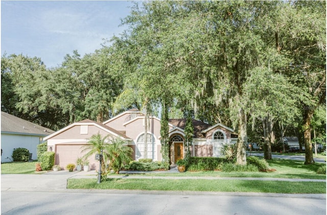 2102 Applegate Dr, Ocoee, FL 34761 - view of front of property with stucco siding, an attached garage, concrete driveway, and a front lawn