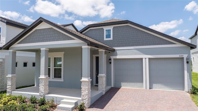 16489 Silver Brook Way, Winter Garden, FL 34787 - craftsman-style house with a porch, stucco siding, a garage, and decorative driveway