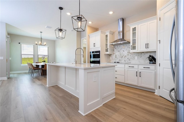 16489 Silver Brook Way, Winter Garden, FL 34787 - kitchen featuring wall chimney range hood, appliances with stainless steel finishes, a sink, light wood-style floors, and recessed lighting
