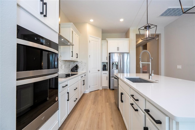 16489 Silver Brook Way, Winter Garden, FL 34787 - kitchen featuring stainless steel appliances, a sink, light wood-style flooring, decorative backsplash, and light countertops