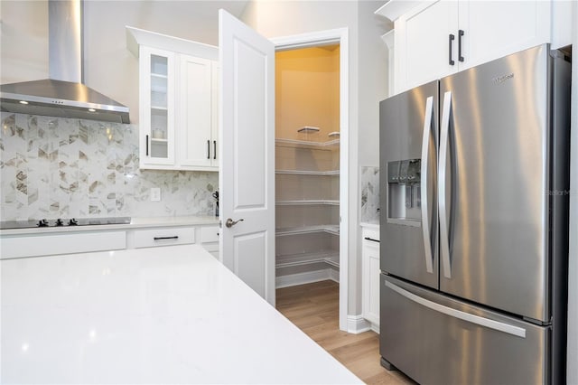 16489 Silver Brook Way, Winter Garden, FL 34787 - kitchen with stainless steel refrigerator with ice dispenser, wall chimney exhaust hood, light countertops, white cabinetry, and black electric stovetop
