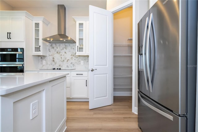 16489 Silver Brook Way, Winter Garden, FL 34787 - kitchen featuring appliances with stainless steel finishes, wall chimney exhaust hood, light wood-style floors, white cabinetry, and light countertops