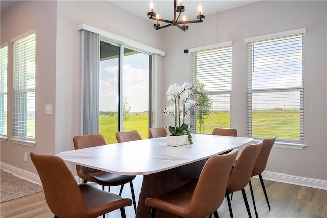 16489 Silver Brook Way, Winter Garden, FL 34787 - dining room with a chandelier, baseboards, light wood-style flooring, and healthy amount of natural light