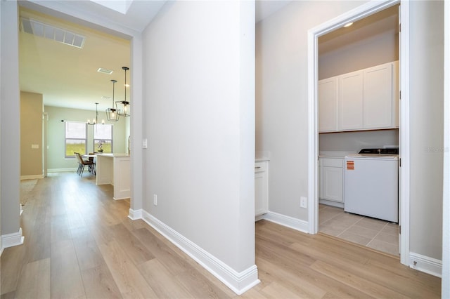 16489 Silver Brook Way, Winter Garden, FL 34787 - hallway with washer / clothes dryer, light wood-type flooring, a chandelier, and baseboards