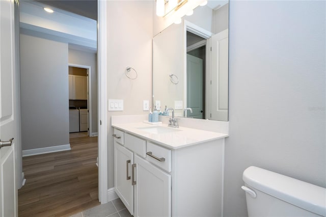 16489 Silver Brook Way, Winter Garden, FL 34787 - bathroom featuring washing machine and clothes dryer, vanity, toilet, wood finished floors, and baseboards