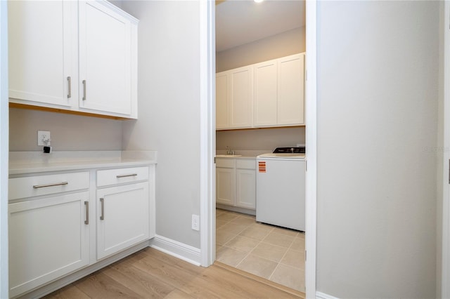 16489 Silver Brook Way, Winter Garden, FL 34787 - laundry area featuring washer / dryer, cabinet space, baseboards, and light wood-type flooring