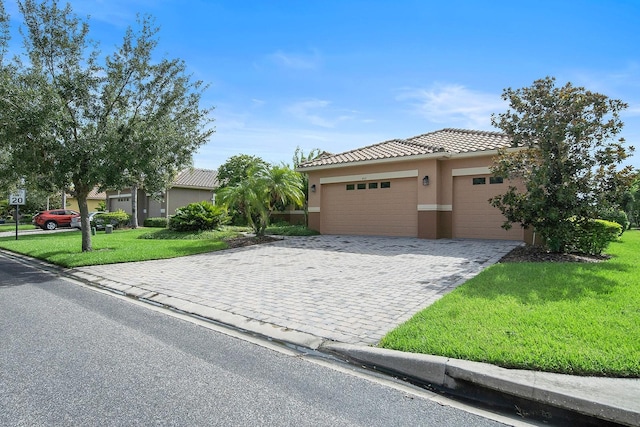 453 Sorrento Rd, Kissimmee, FL 34759 - view of front facade with a front lawn, stucco siding, a garage, decorative driveway, and a tiled roof