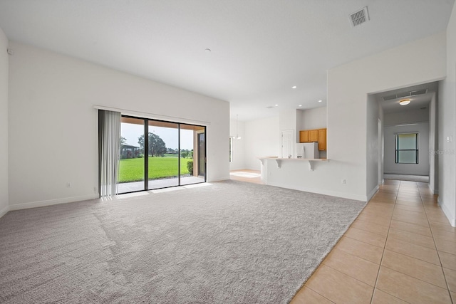 453 Sorrento Rd, Kissimmee, FL 34759 - unfurnished living room with light carpet, light tile patterned floors, baseboards, and recessed lighting