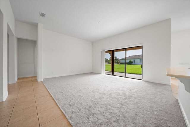 453 Sorrento Rd, Kissimmee, FL 34759 - unfurnished living room with light carpet, baseboards, and light tile patterned flooring