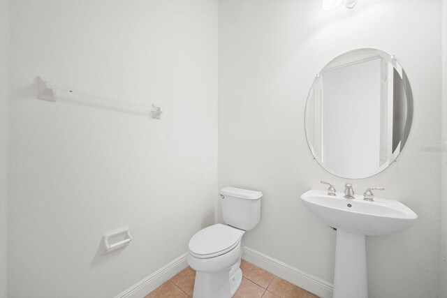 453 Sorrento Rd, Kissimmee, FL 34759 - half bath featuring tile patterned flooring, toilet, a sink, and baseboards