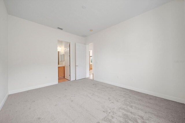 453 Sorrento Rd, Kissimmee, FL 34759 - unfurnished bedroom with light colored carpet, baseboards, and ensuite bathroom