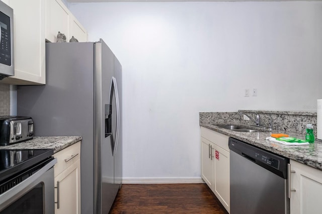 3229 Cupid Pl, Kissimmee, FL 34747 - kitchen with appliances with stainless steel finishes, a sink, dark wood-style floors, light stone countertops, and white cabinetry