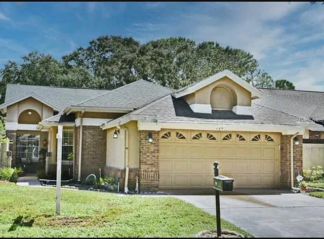 724 Barrington Cir, Winter Springs, FL 32708 - ranch-style house with a garage, concrete driveway, brick siding, a front lawn, and roof with shingles