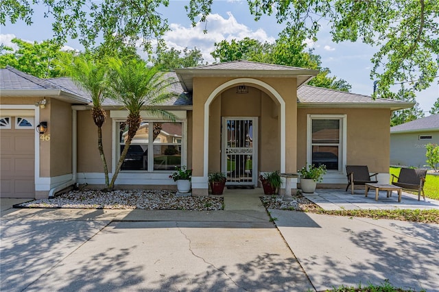46 Frenora Ln, Palm Coast, FL 32137 - property entrance with stucco siding and an attached garage
