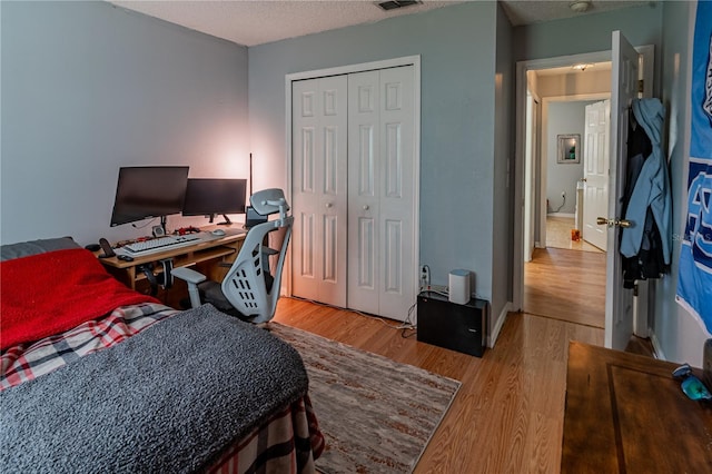 46 Frenora Ln, Palm Coast, FL 32137 - bedroom with wood finished floors, a textured ceiling, a closet, and an office area