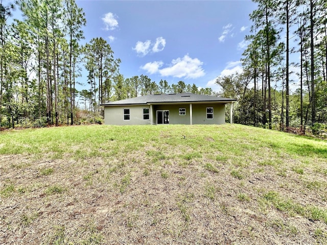 9335 N Fairy Lilly Dr, Citrus Springs, FL 34433 - back of house with a lawn and stucco siding