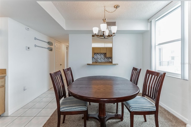3360 Ocean Shore Blvd Unit 4050, Ormond Beach, FL 32176 - dining space featuring a chandelier, a textured ceiling, and baseboards