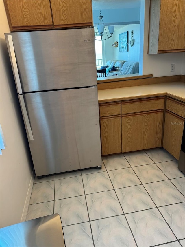 3360 Ocean Shore Blvd Unit 4050, Ormond Beach, FL 32176 - kitchen with freestanding refrigerator, light marble finish flooring, light countertops, and baseboards