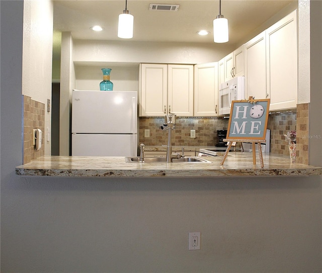 1108 Northlake Dr Unit 1108, Sanford, FL 32773 - kitchen with white appliances, a sink, backsplash, a peninsula, and pendant lighting